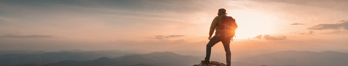 Hiker looking out over mountains at sunset